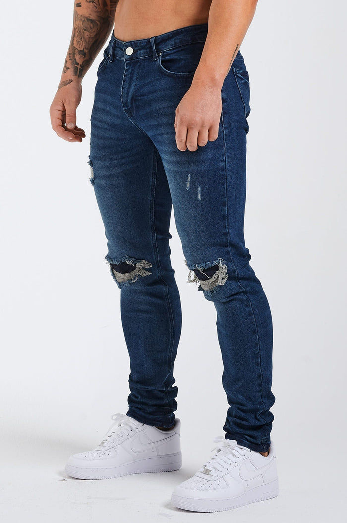 SLIM JEANS 2.0 DISTRESSED UND PATCHED – DUNKELBLAU